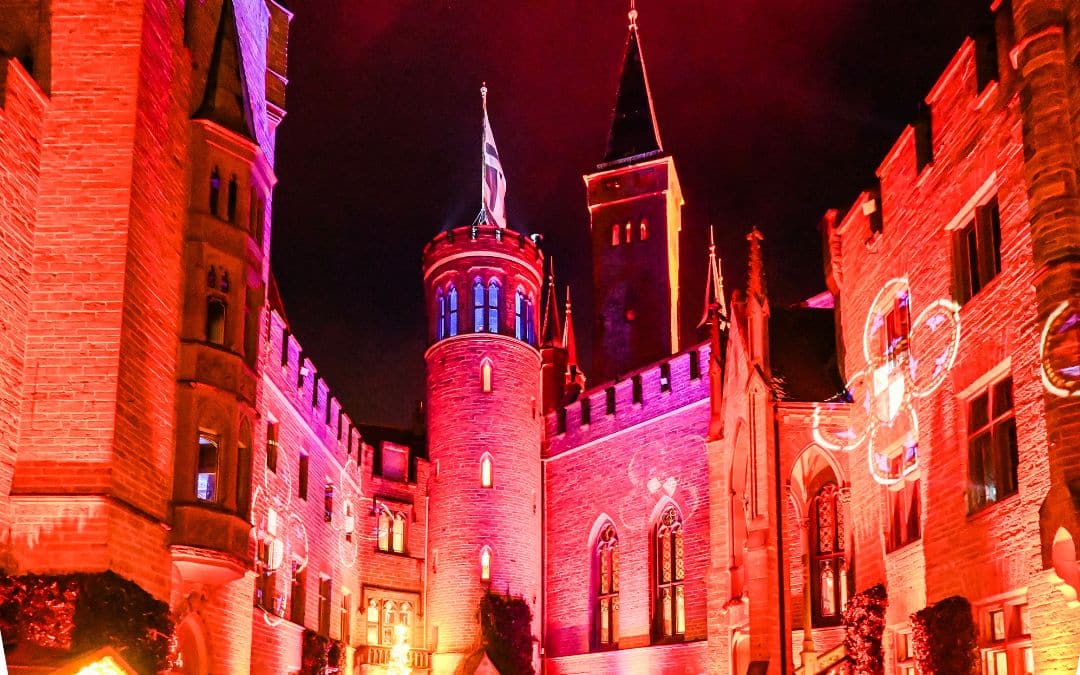 Hohenzollern Castle, royal winter magic - light show in the castle courtyard, lighting in shades of red, white flower ornaments on the outer walls - angiestravelroutes.com