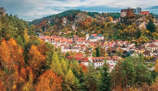 Fränkische Schweiz, Pottenstein, Bayern - Stadtansicht von Pottenstein, umgeben von herbstlichen Wäldern