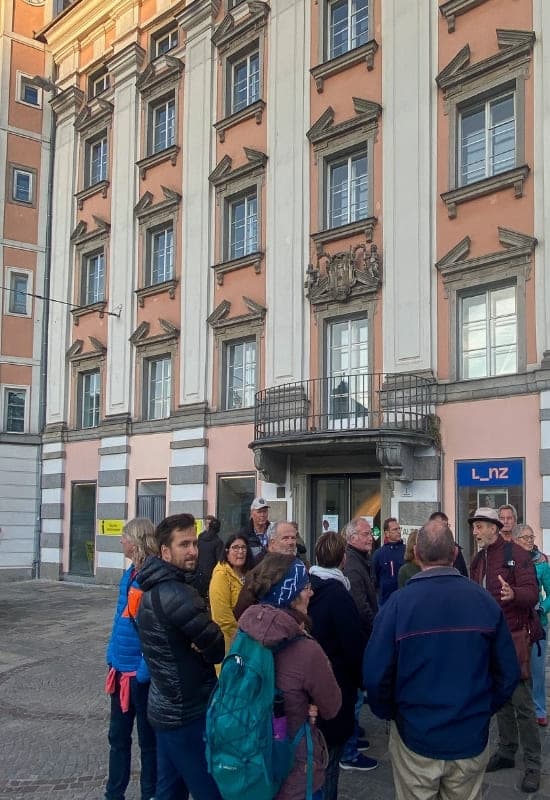 Altes Rathaus, Hauptplatz, Linz - Gruppe vor dem Alten Rathaus, über dem Erdgeschoss ein relativ kleiner Balkon mit Metallgeländer - angiestravelroutes.com