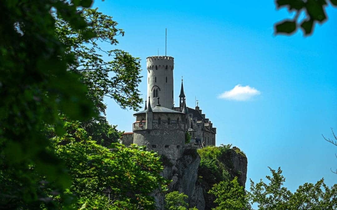 Aussichtspunkt bei der Ruine Alt-Lichtenstein: Grandioser Ausblick auf das nahegelegene Schloss Lichtenstein, links im Bild Laubbäume - angiestravelroutes.com