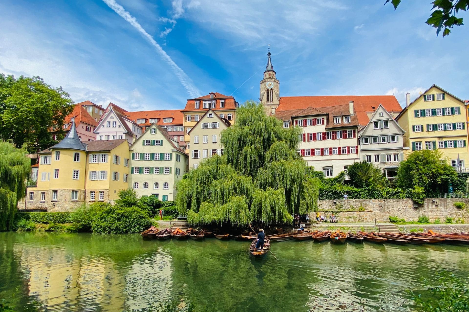 Tübingen, Neckarfront - View from the Neckar island/Platanenallee to the punt landing stage Hölderlin-Turm with large weeping willow behind the barges and the old town panorama, on the left in the picture the yellow Hölderlin-Turm - angiestravelroutes.com