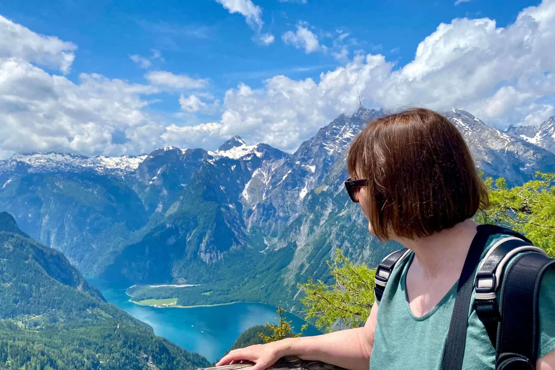 Königssee, Berchtesgadener Land - Frau mit Sonnenbrille im Halbprofil blickt vom Jenner-Aussichtspunkt auf den Königssee und die Berchtesgadener Alpen - angiestravelroutes.com