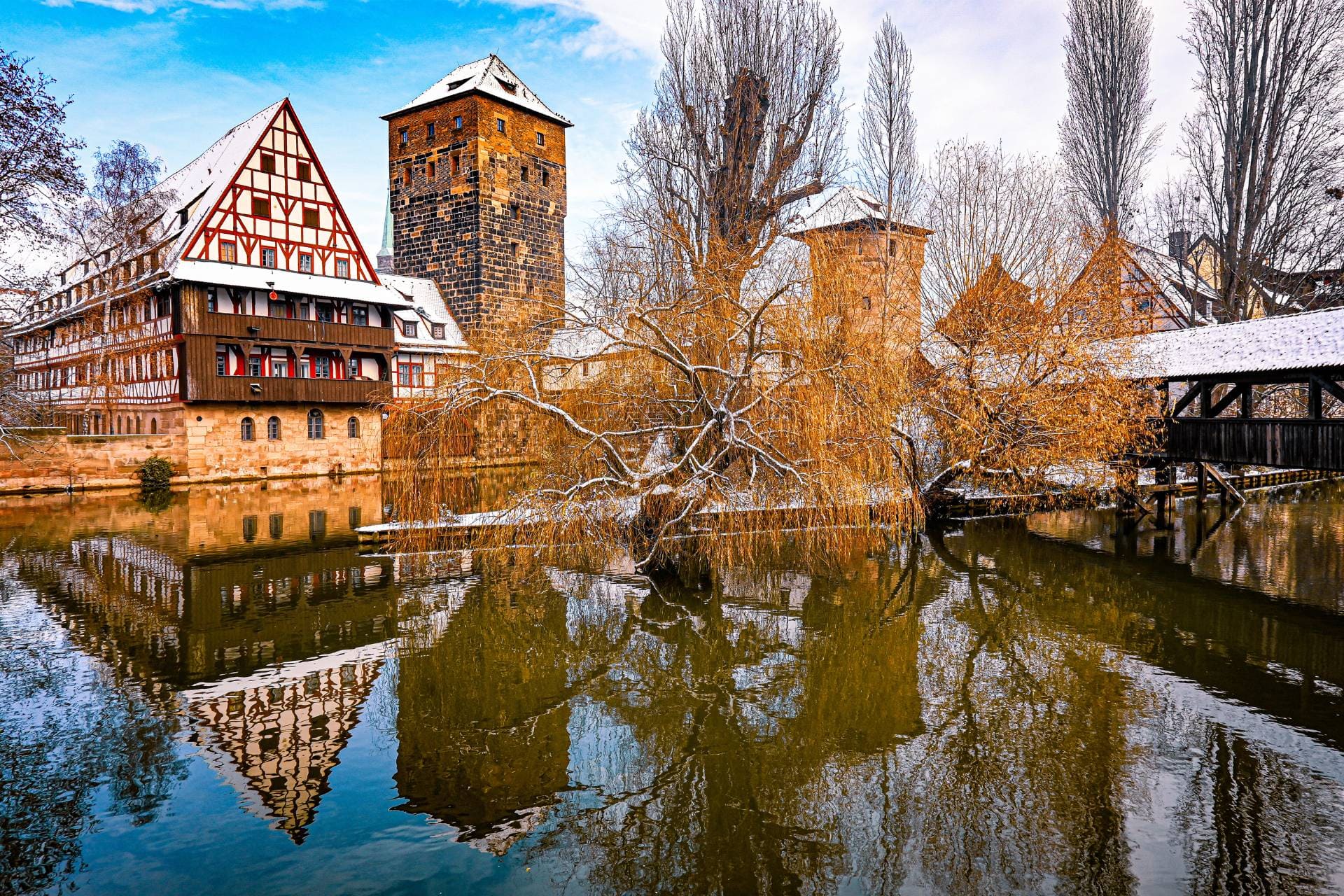 Nürnberg - Henkersteg Henkerhaus Weinstadel - Blick von der Maxbrücke auf das Ensemble an einem Wintertag - die Dächer sind schneebedeckt, die Gebäude spiegeln sich im Wasser der Pegnitz - angiestravelroutes.com