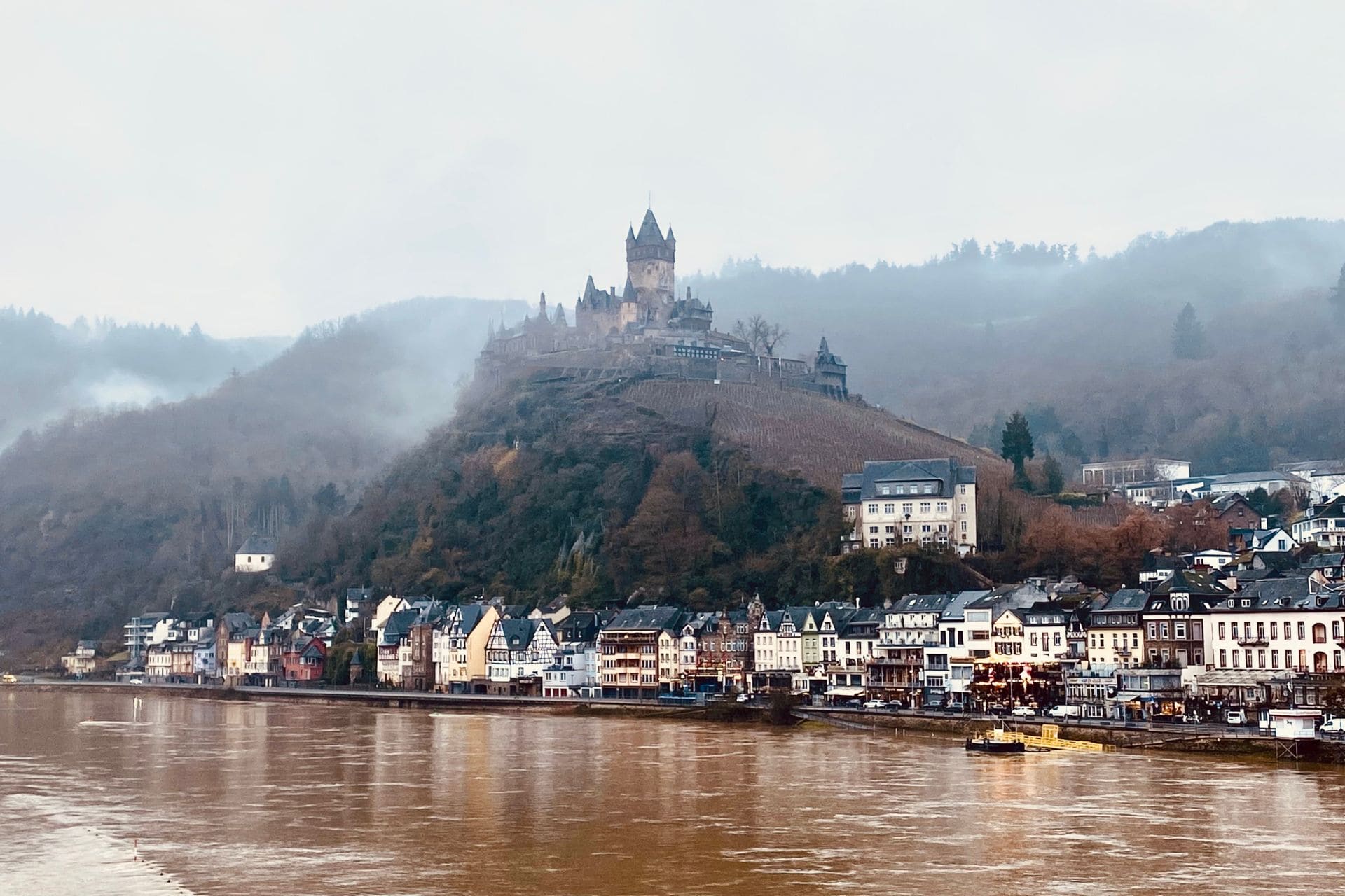 The Reichsburg Cochem above the old town of Cochem - fog rises around the castle hill - angiestravelroutes.com