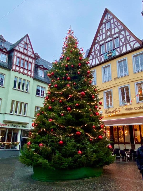 Cochem, Marktplatz - der mit roten Kugeln geschmückte Weihnachtsbaum, im Hintergrund zwei Häuser mit Fachwerkgiebeln - angiestravelroutes.com