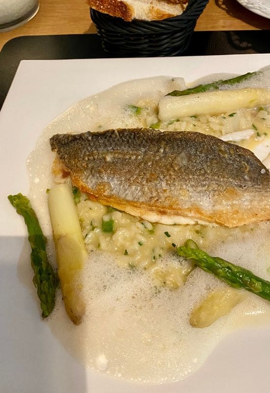 Sea bass fillet with green and white asparagus on a bed of risotto at Gerhards Genussgesellschaft