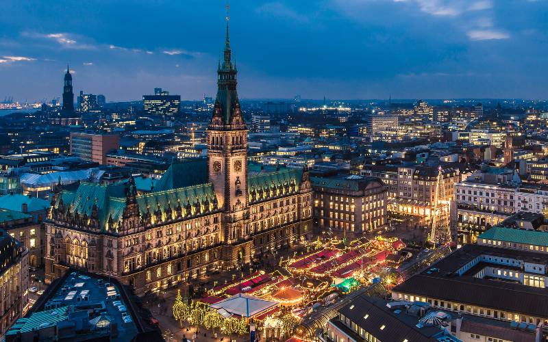 Christmas Market Hamburg: Historic Christmas Market at the Rathausmarkt - Aerial view of the Rathausmarkt with the illuminated city hall, in the background a wide view over the city - angiestravelroutes.com