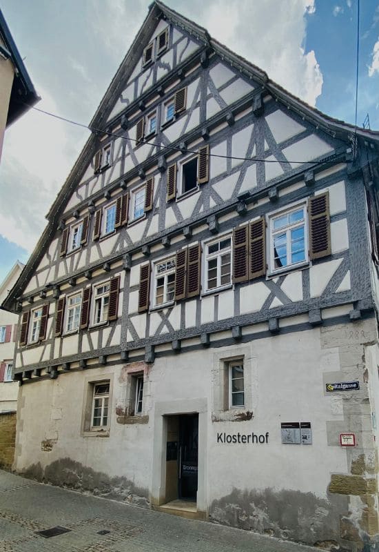 Herrenberg Old Town, Bebenhäuser Klosterhof - Half-timbered house with plastered base, upper floors with light gray painted half-timbering and dark brown shutters - angiestravelroutes.com