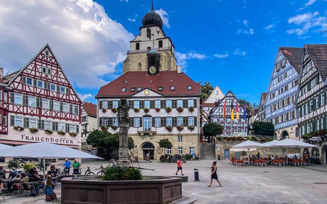 Der Marktplatz von Herrenberg mit dem Marktbrunnen, Rathaus (überragt vom Turm der Stiftskirche) und einigen Fachwerkhäusern - angiestravelroutes.com