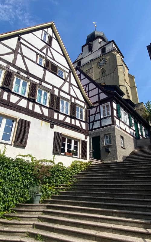 Herrenberg Altstadt - Treppen zur Stiftskirche - links von der Treppe zwei Fachwerkhäuser und der dahinter herausragende Turm der Stiftskirche - angiestravelroutes.com