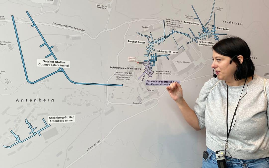 Dokumentation Obersalzberg, Berchtesgaden - Frau mit Headset und weißem Pullover deutet auf einen großen Übersichtsplan - angiestravelroutes.com