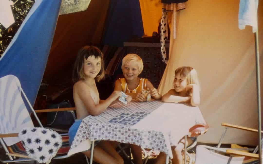 Campsite near Poreč, Croatia (then Yugoslavia), 1967 - three girls aged 7 - 8 sitting laughing at a camping table with playing cards on it - angiestravelroutes.com