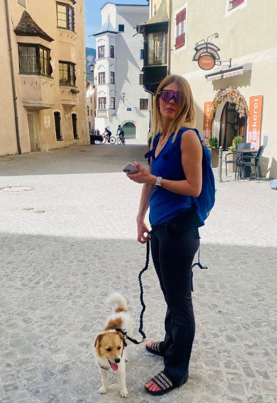 Rattenberg, Tirol, Österreich - junge Frau mit Sonnenbrille und kleinem Hund an der Leine - angiestravelroutes.com