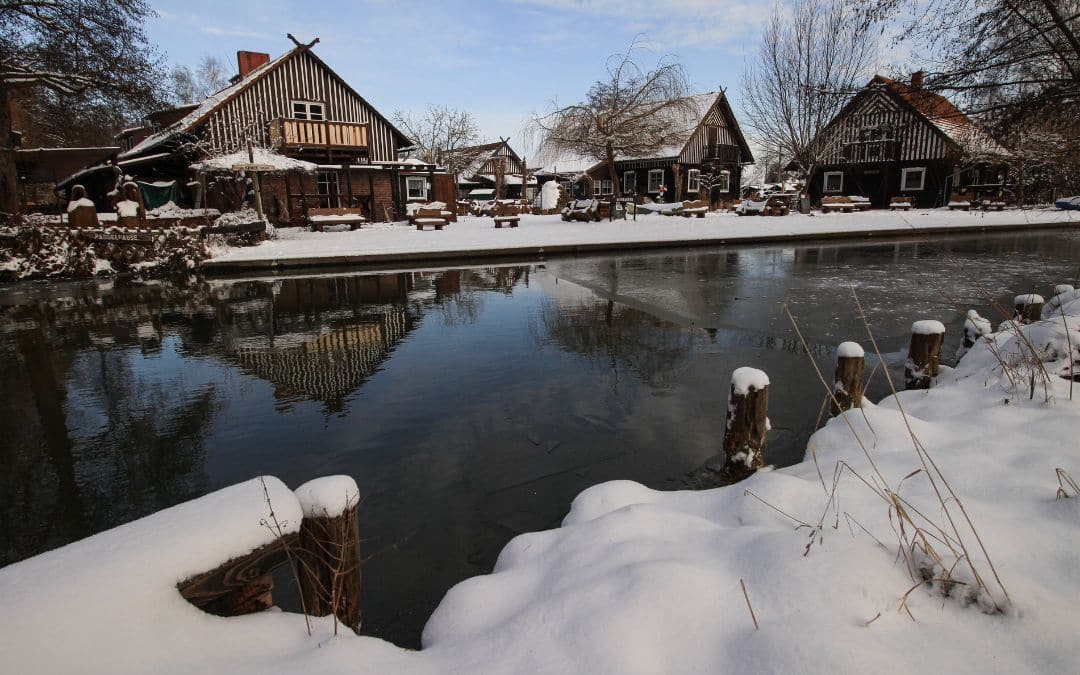 Spreewald, Brandenburg, in winter - typical Spreewald houses in a wintry landscape reflected in the water of a canal