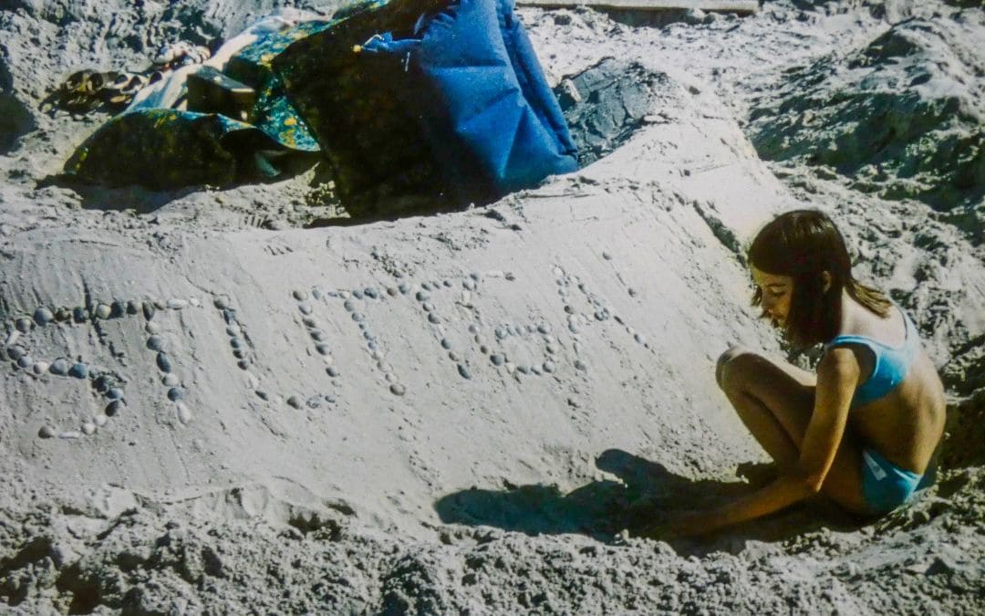 St. Peter-Ording, North Sea coast, Schleswig-Holstein - me, 12 at the time, squatting in the sand in front of my sandcastle. The lettering "STUTTGA..." is not quite finished yet - angiestravelroutes.com