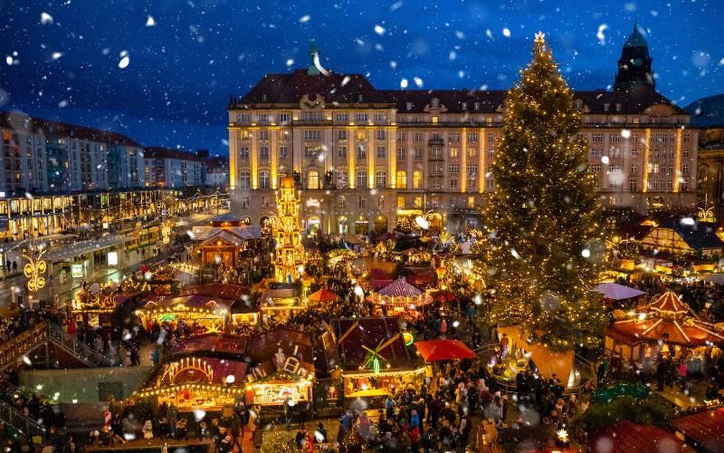 Altmarkt Dresden bei Schneefall am Abend mit Weihnachtshütten, Weihnachtsbaum und Weihnachtspyramide.