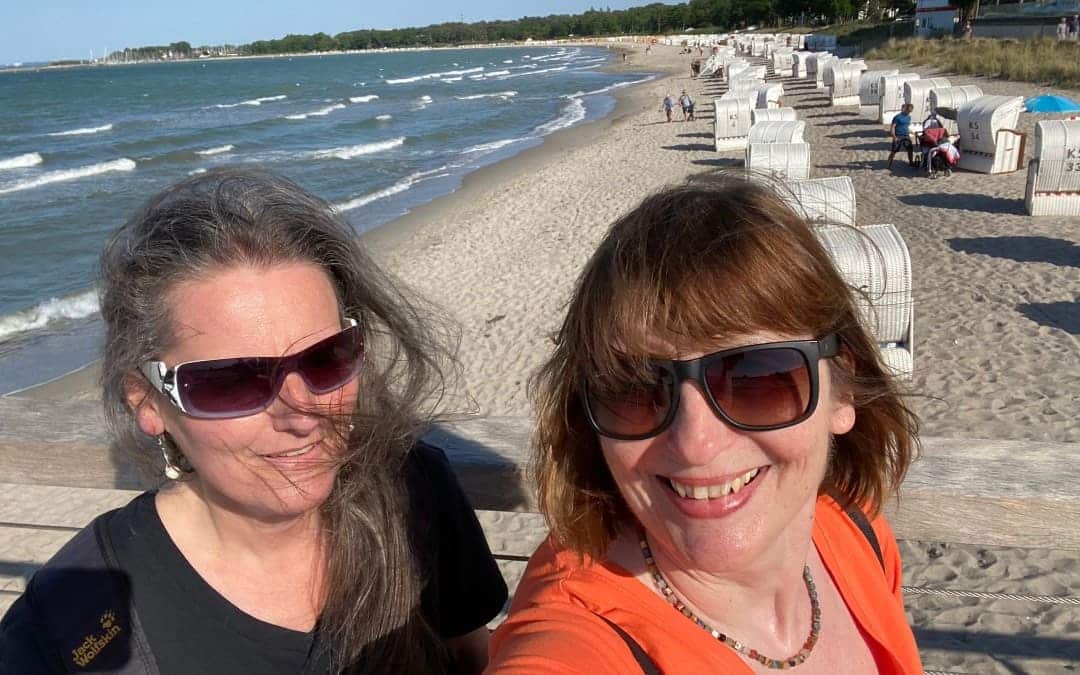 Timmendorfer Strand - Selfie Jutta und Angelika auf Brücke - im Hintergrund Strand mit Strandkörben - angiestravelroutes.com