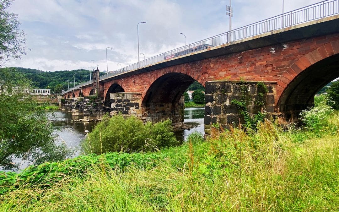Seitliche Ansicht der Römerbrücke mit antiken Basaltpfeilern im Fluss