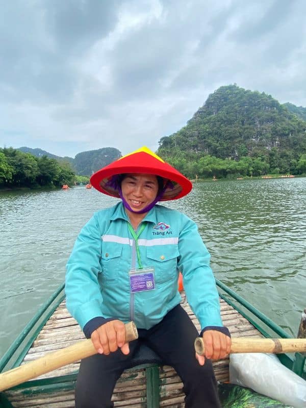 Trang An, Vietnam: Vietnamesin mit Kegelhut beim Rudern durch die Karstlandschaft - angiestravelroutes.com