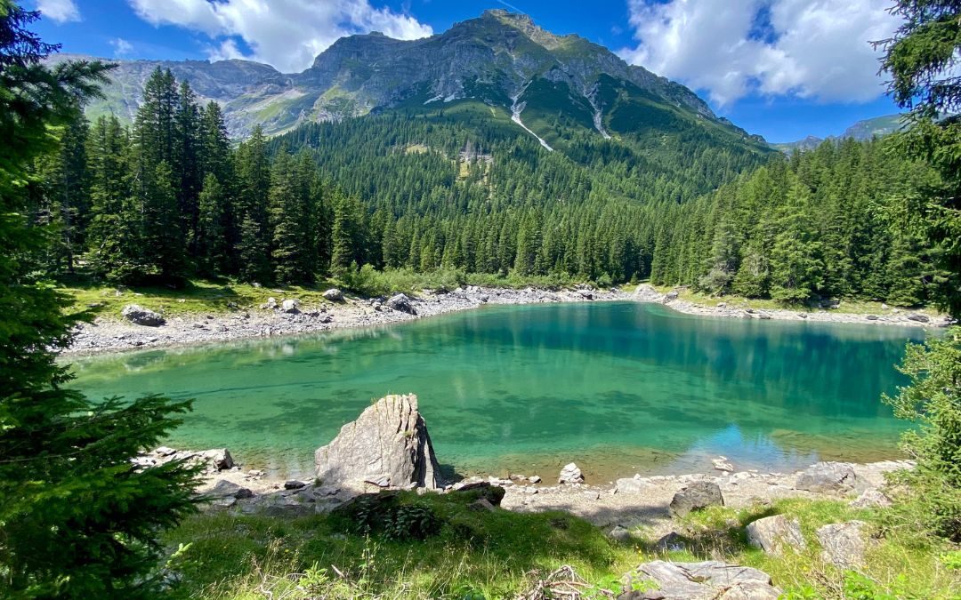 The turquoise shimmering Obernberger See with the mighty Tribulaun in the background - angiestravelroutes.com