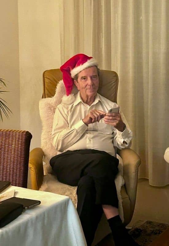 Mein Vater mit Nikolausmütze im Relax-Sessel, das Handy in der Hand - angiestravelroutes.com