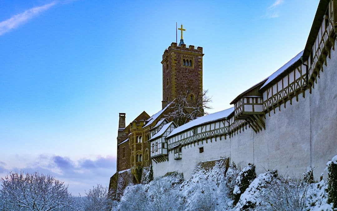 Wartburg Castle, Eisenach, Thuringia, in winter - side view of the castle, photographed from the vantage point in front of the gatehouse - roofs, trees and the mountain spur below the castle are covered with a thin layer of snow - angiestravelroutes.com