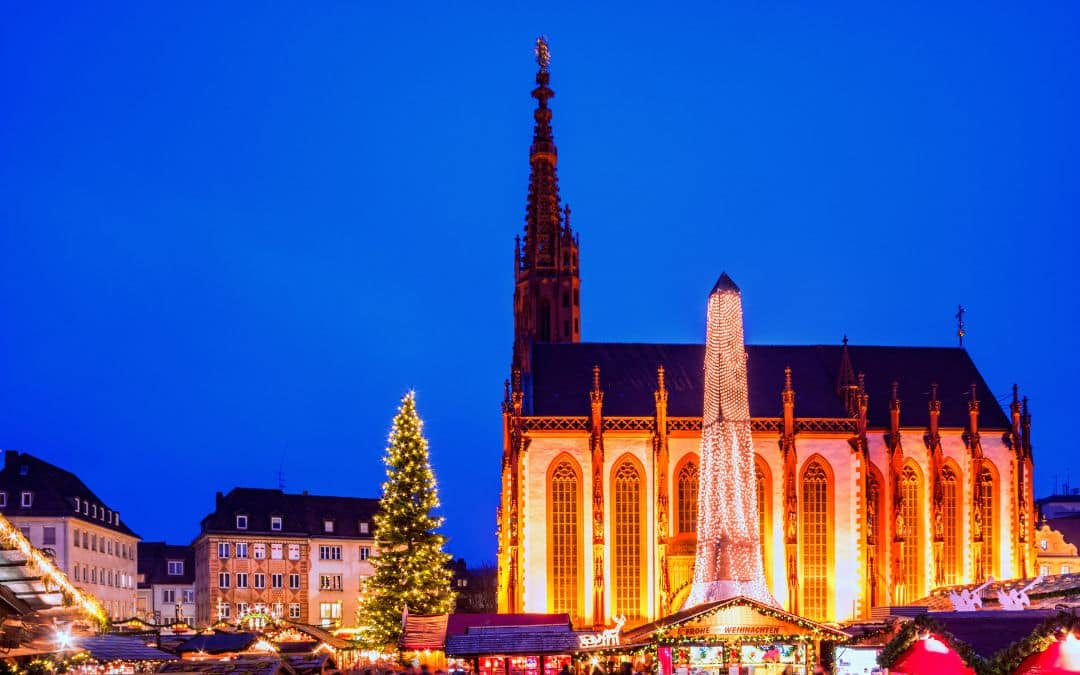 Marketplace Würzburg, Bavaria - blue hour at the Christmas market, the illuminated Marienkapelle fills the right half of the picture, in front of it Christmas stalls, left of the chapel the Christmas tree